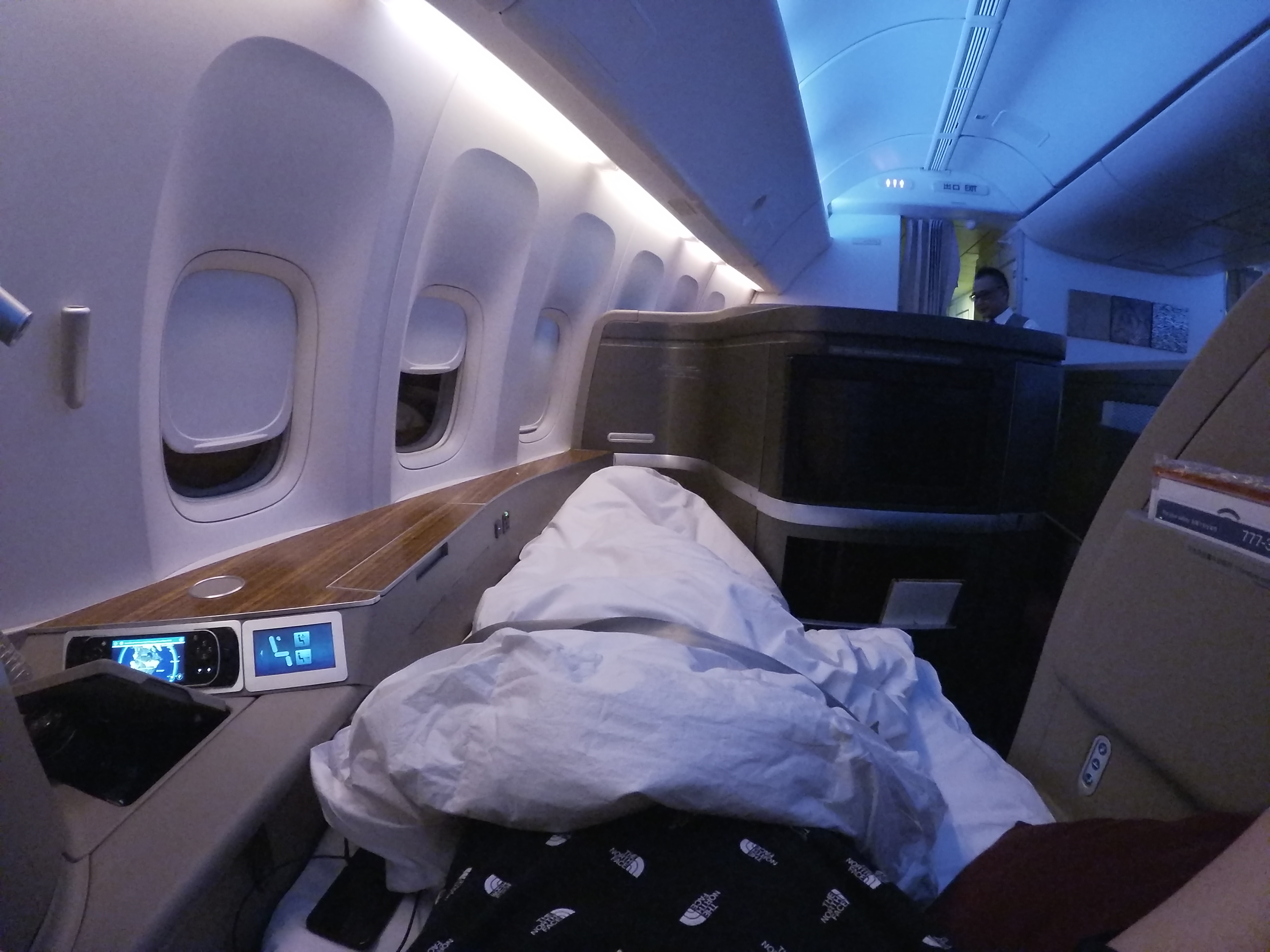 a person lying in a bed in an airplane