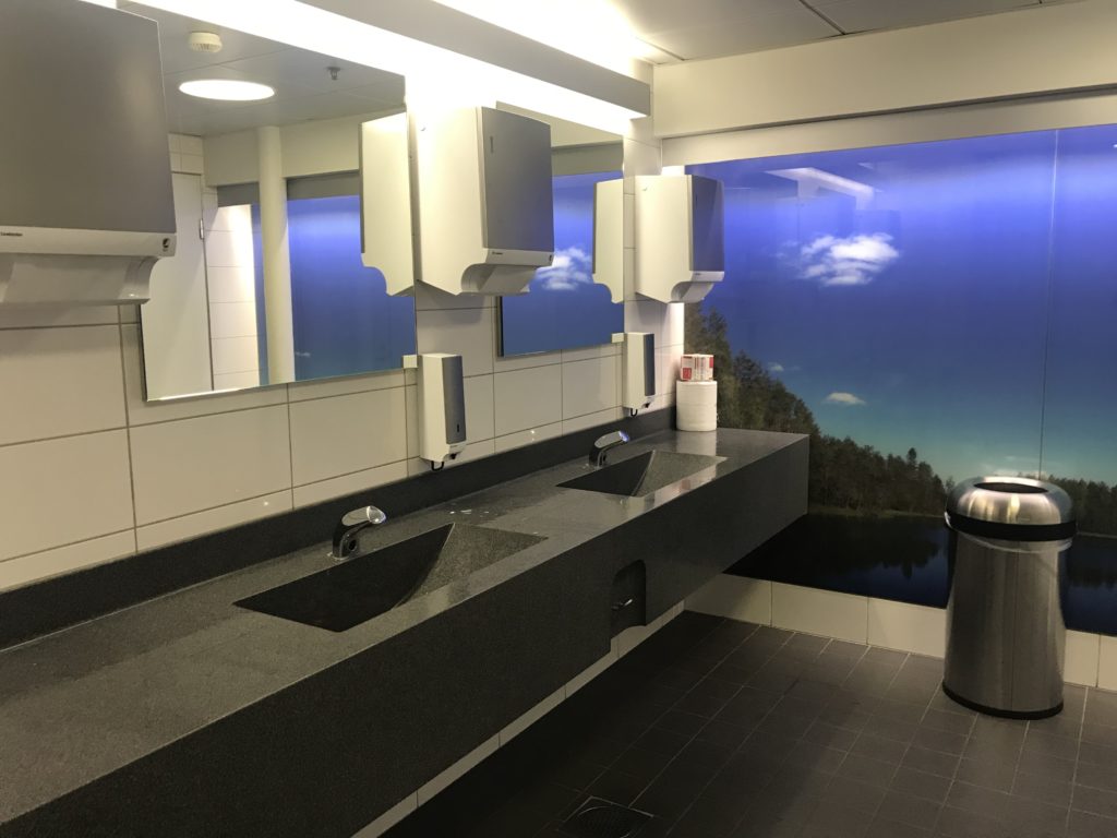 a bathroom with sinks and trash cans