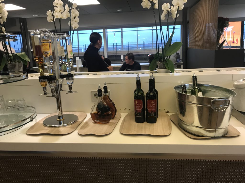 a bar counter with bottles of liquor and a bucket of liquid