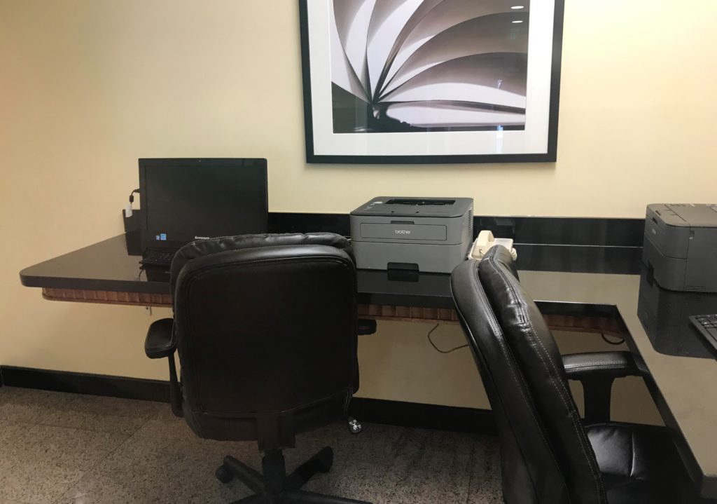 a desk with chairs and a printer