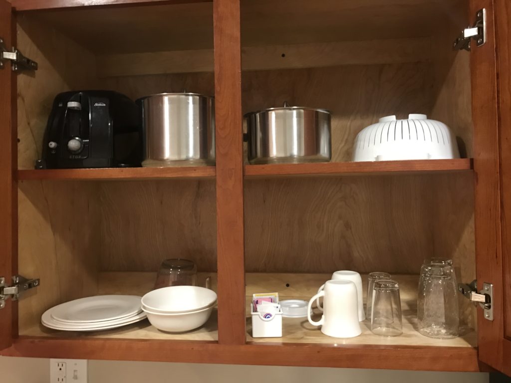 a shelf with utensils and cups on it