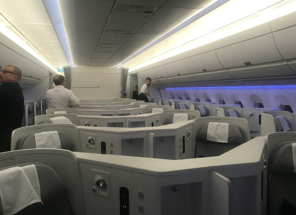a plane with seats and people sitting in the back