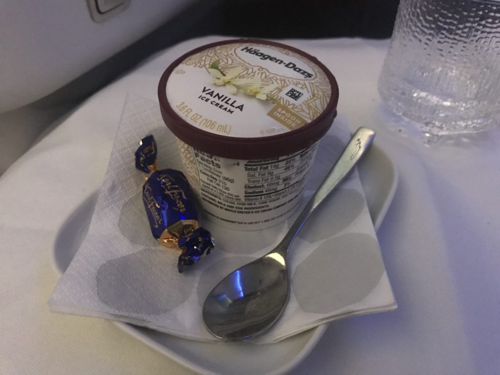 a cup of ice cream and a spoon on a plate
