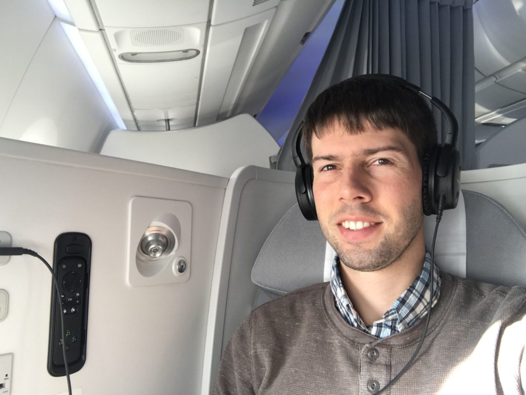 a man wearing headphones and sitting in an airplane
