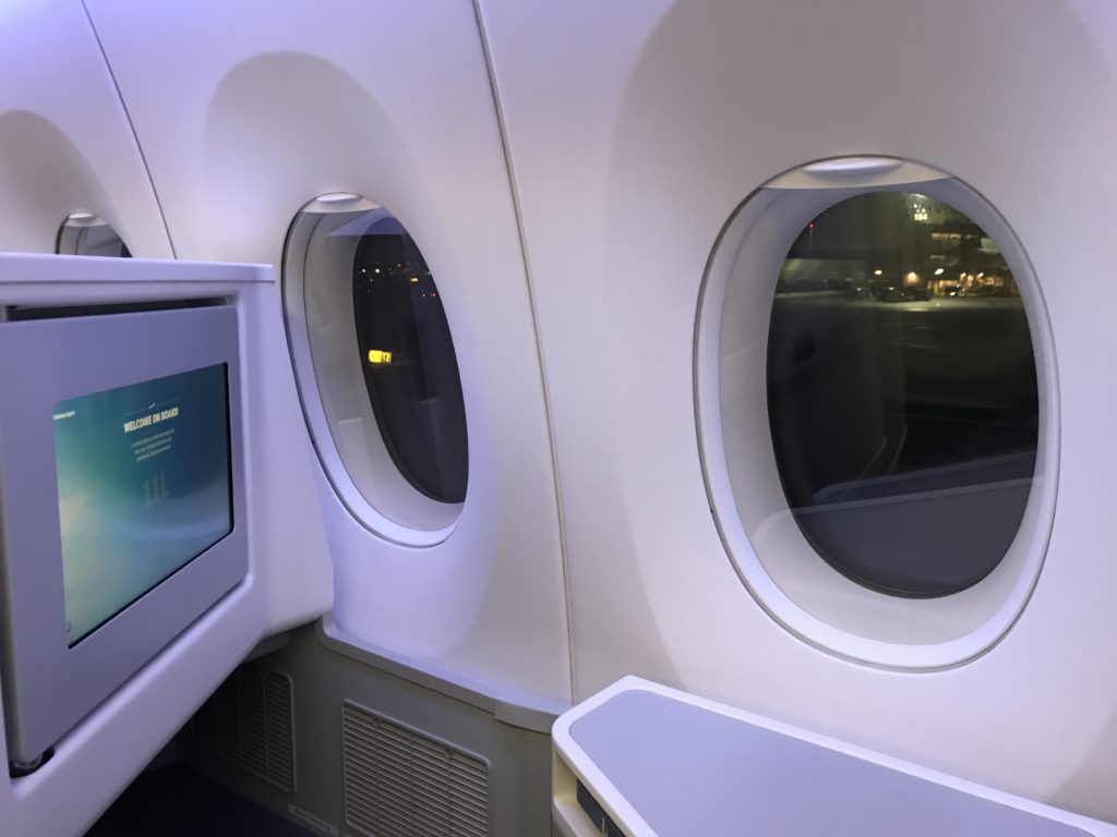 a window with round windows and a television in an airplane
