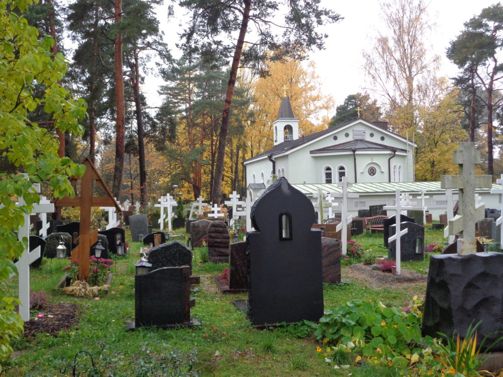 a cemetery with white crosses and trees