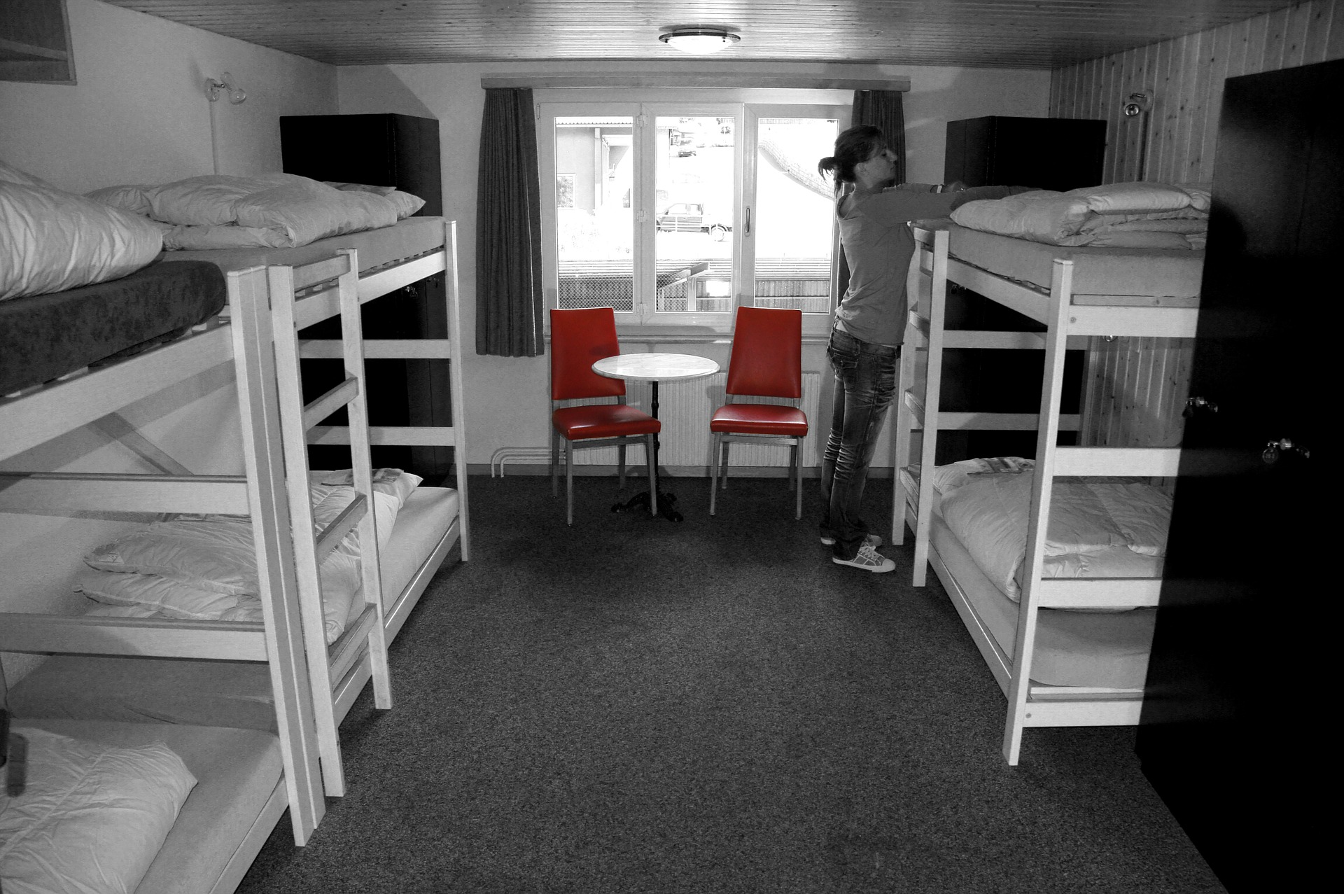 a woman standing in a room with bunk beds