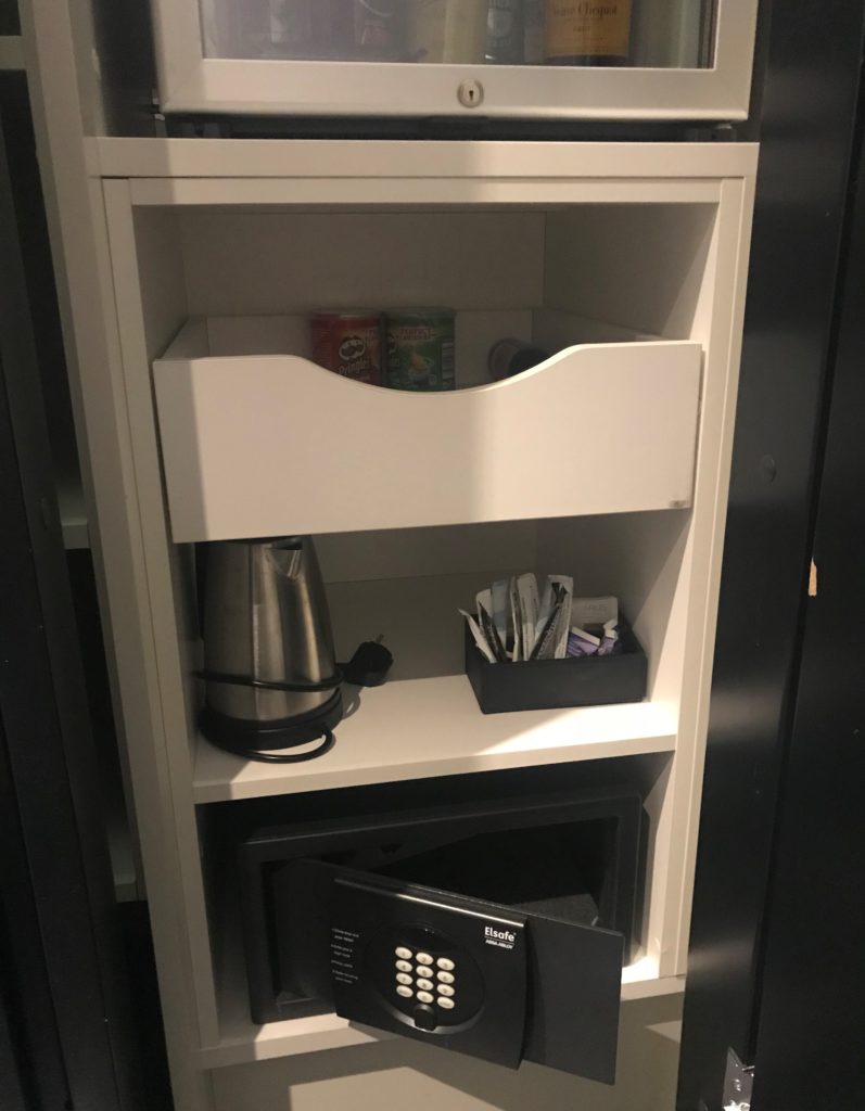 a white shelf with a drawer and a microwave