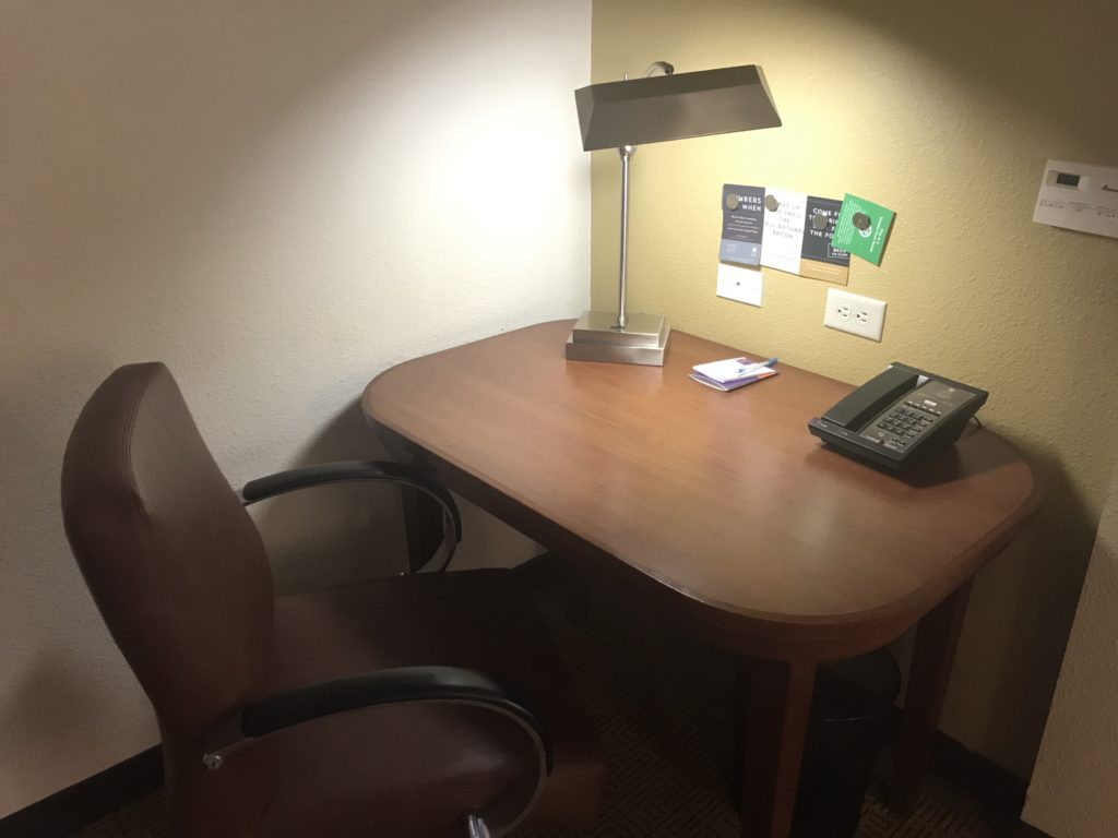 a desk with a telephone and a lamp