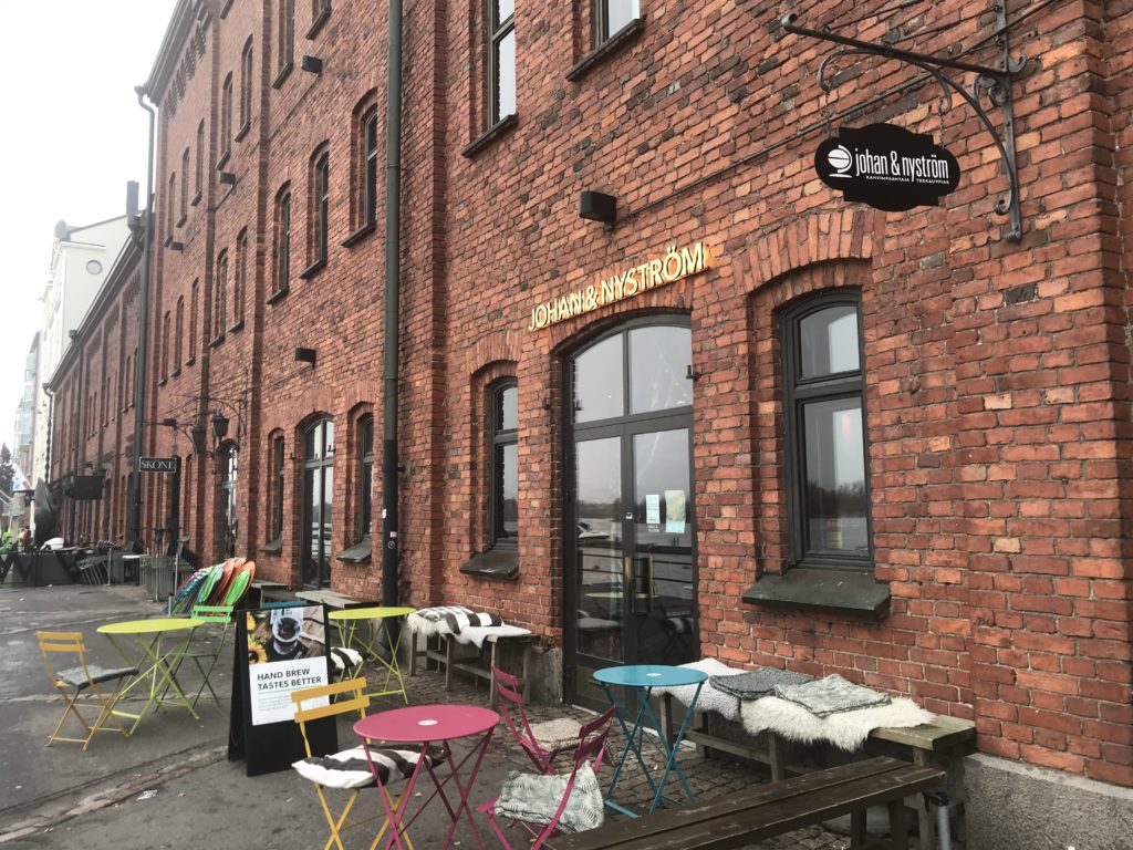 a brick building with tables and chairs outside