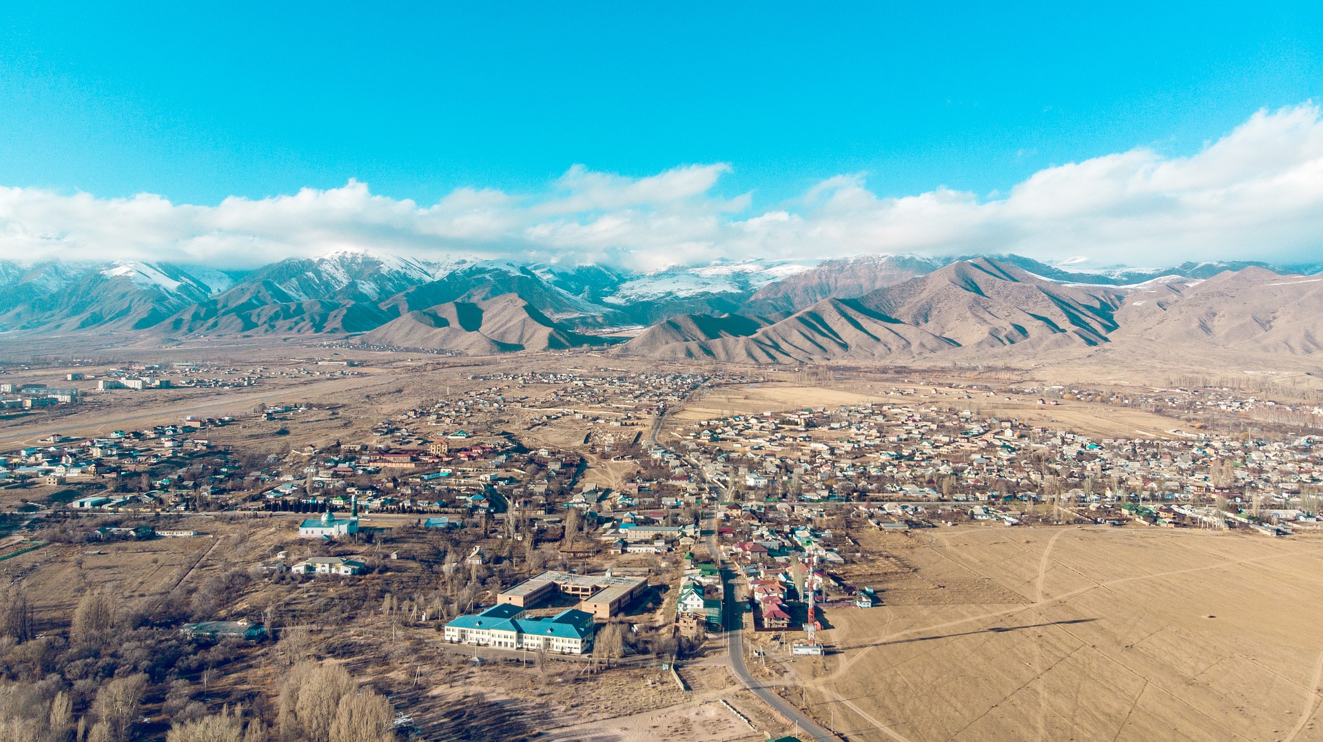 a city in a valley with mountains in the background