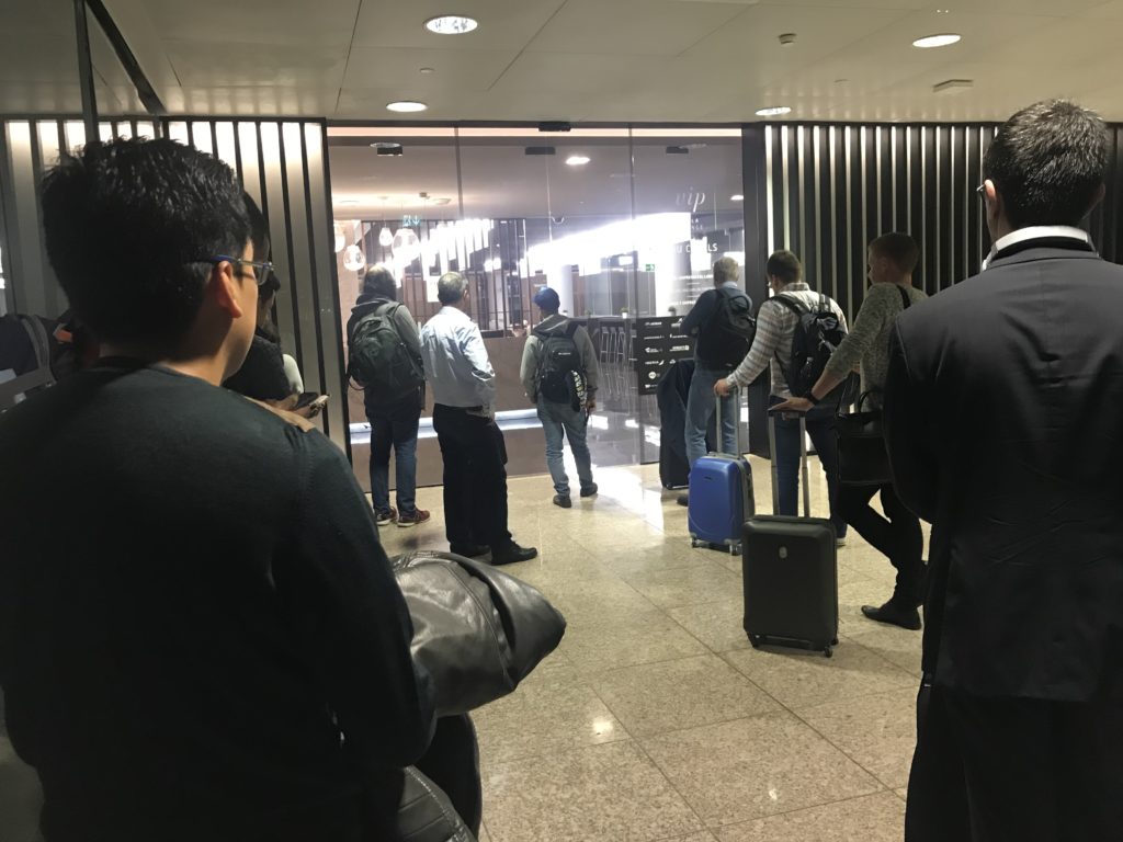 a group of people standing in a hallway with luggage