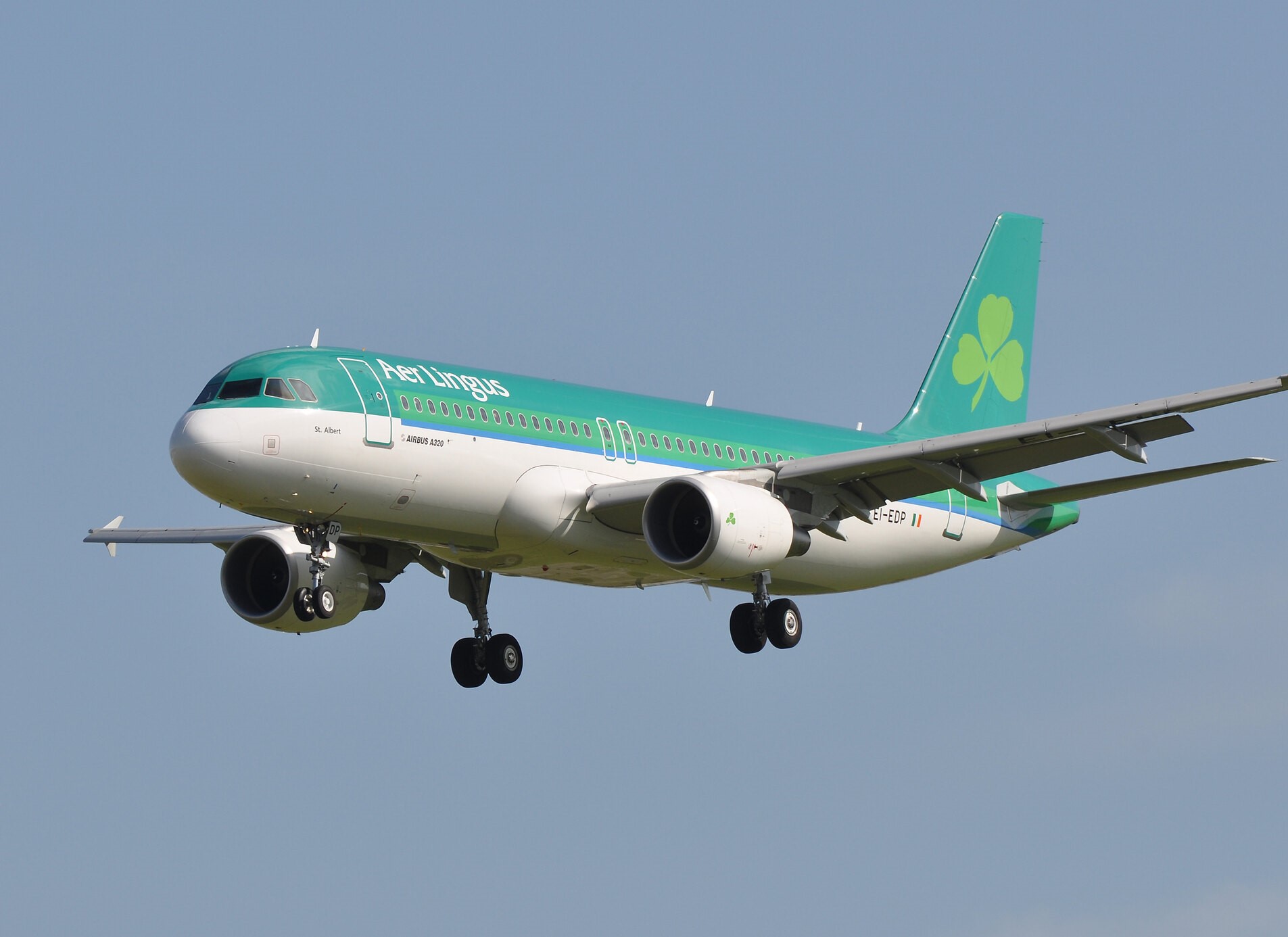 a green and white airplane in the sky