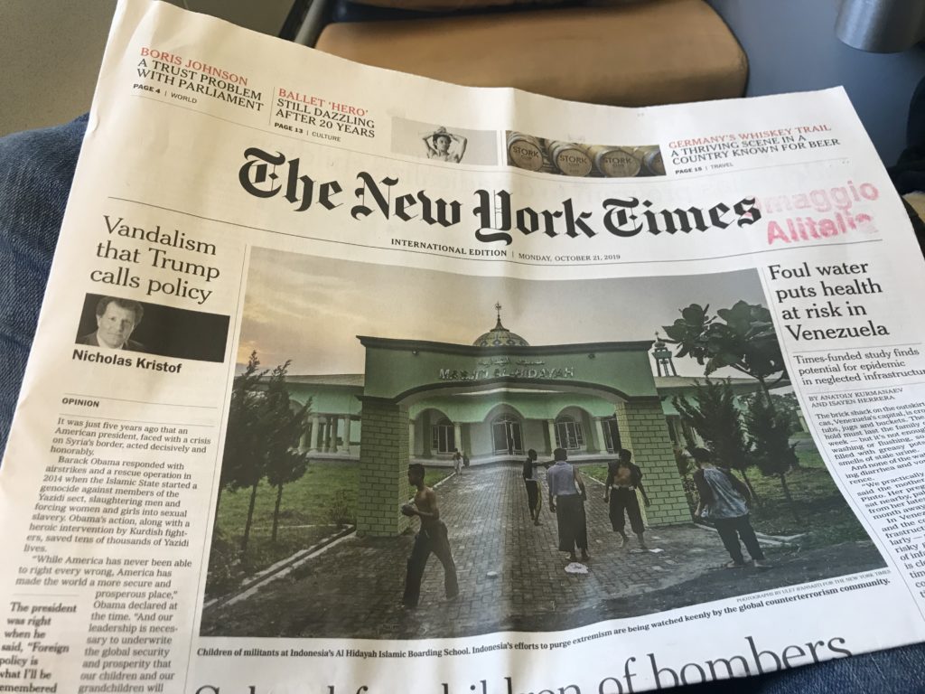 a newspaper with a picture of a building and people