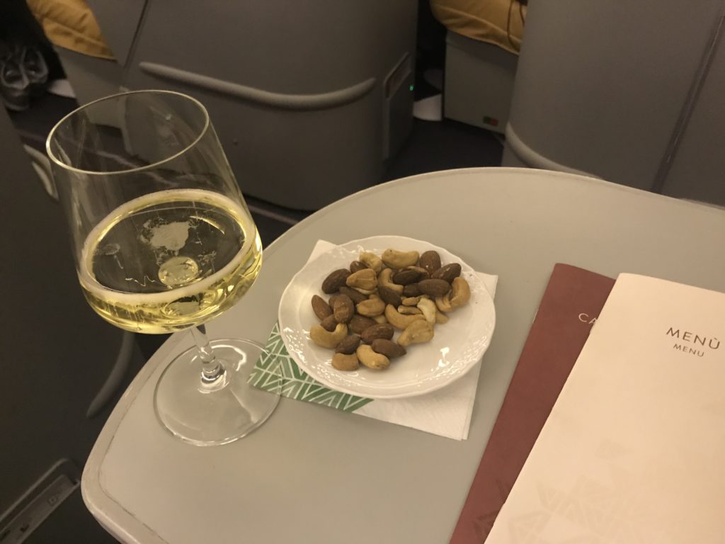 a plate of nuts and a glass of wine on a table