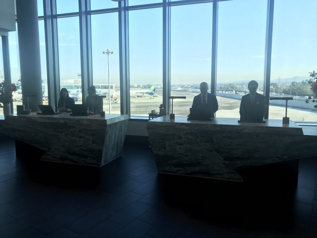 people standing at a desk in front of a window