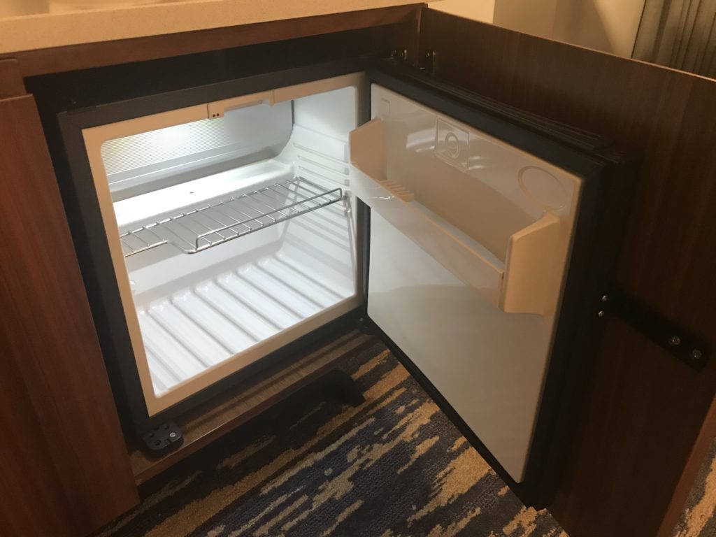 a small refrigerator with a shelf