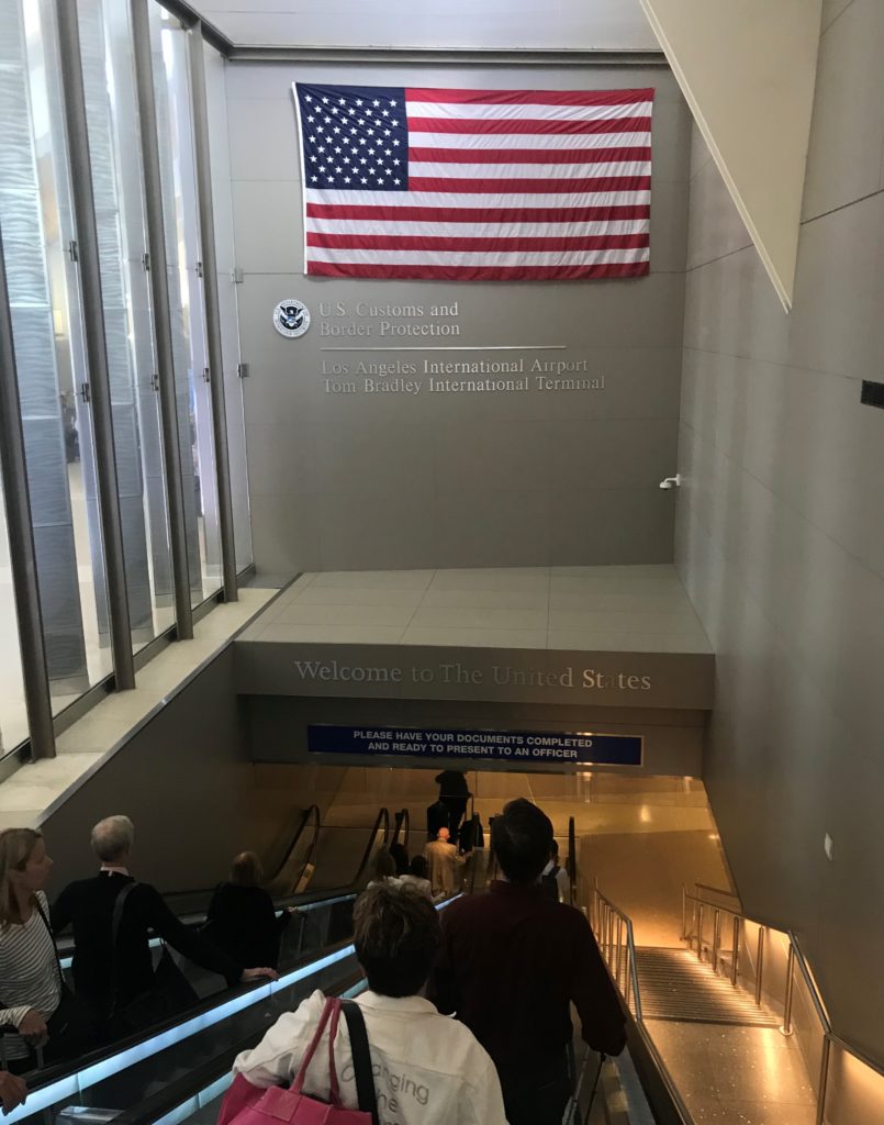 a group of people walking up stairs in a building with a flag from the wall