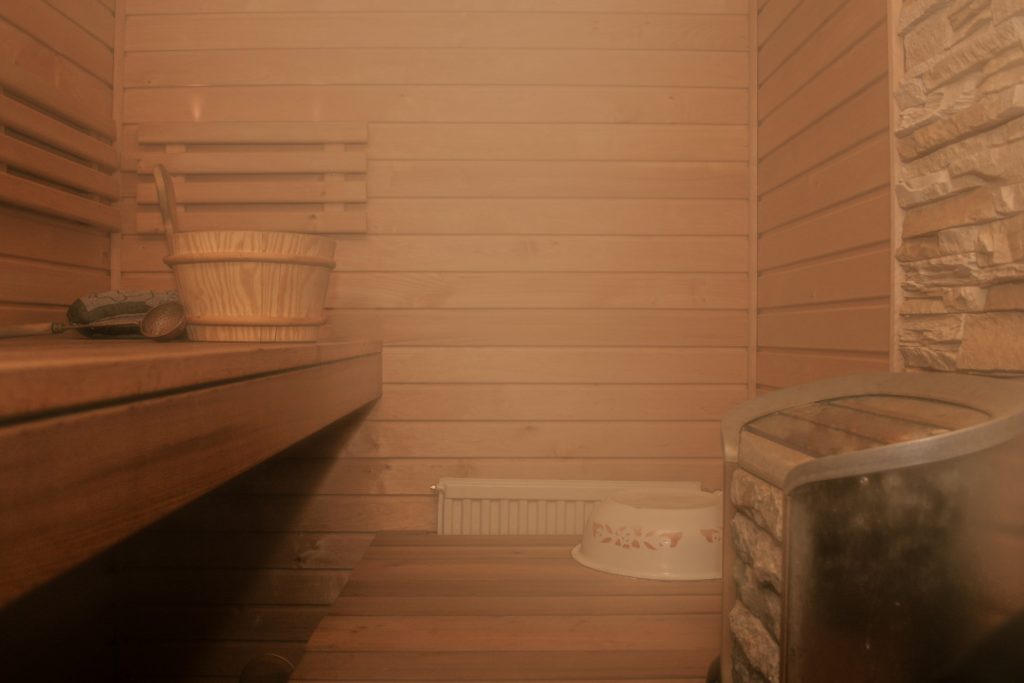 a wooden bench and a bowl on a table in a sauna