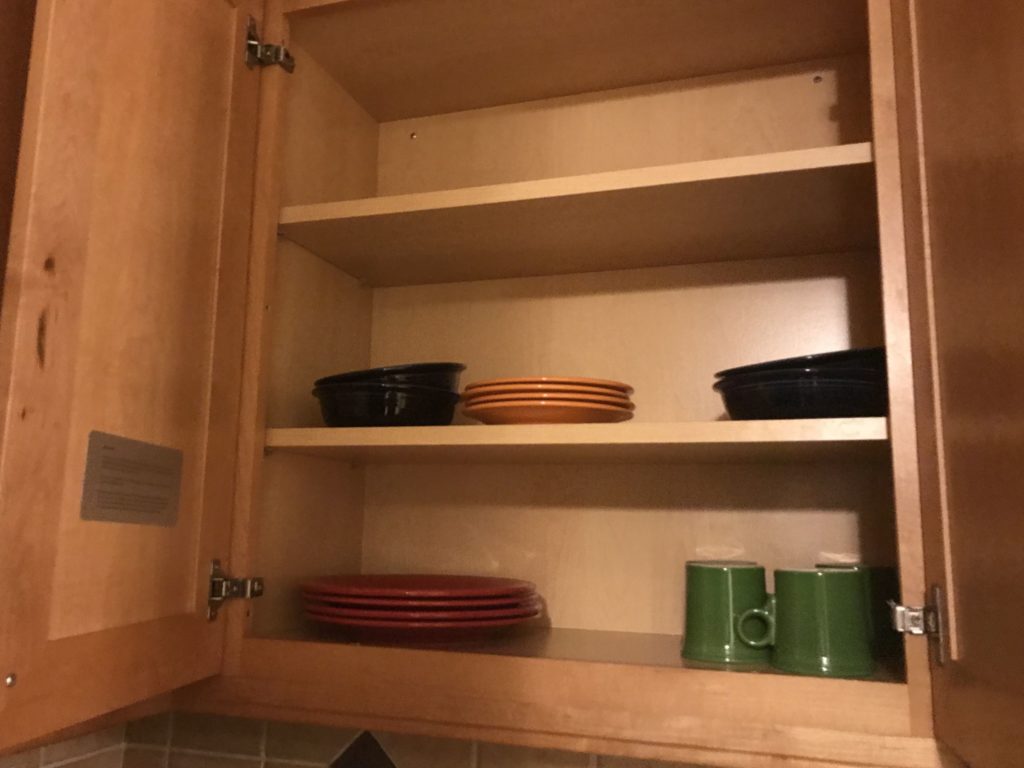 a shelf with plates and cups in it