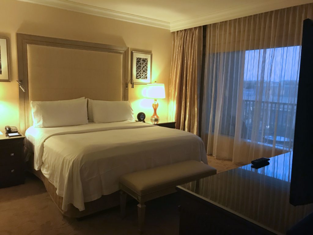 a bed with a lamp and a table in a hotel room