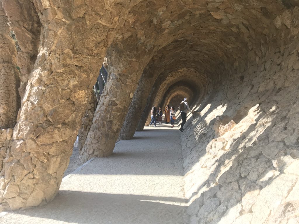a stone tunnel with people walking on the ground