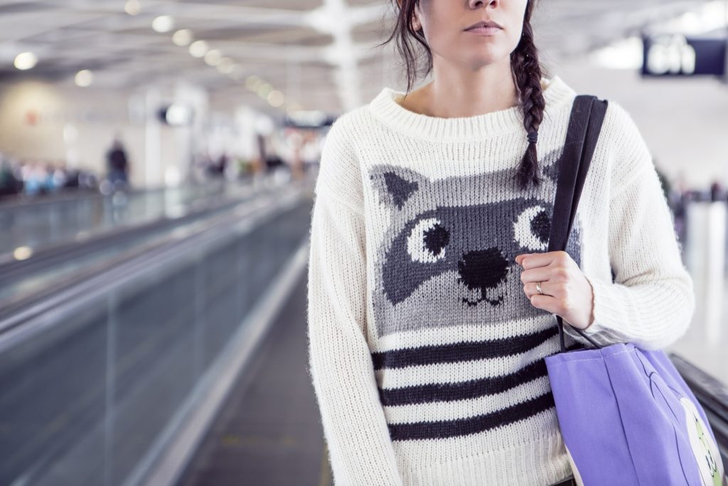 a woman wearing a sweater with a cat design