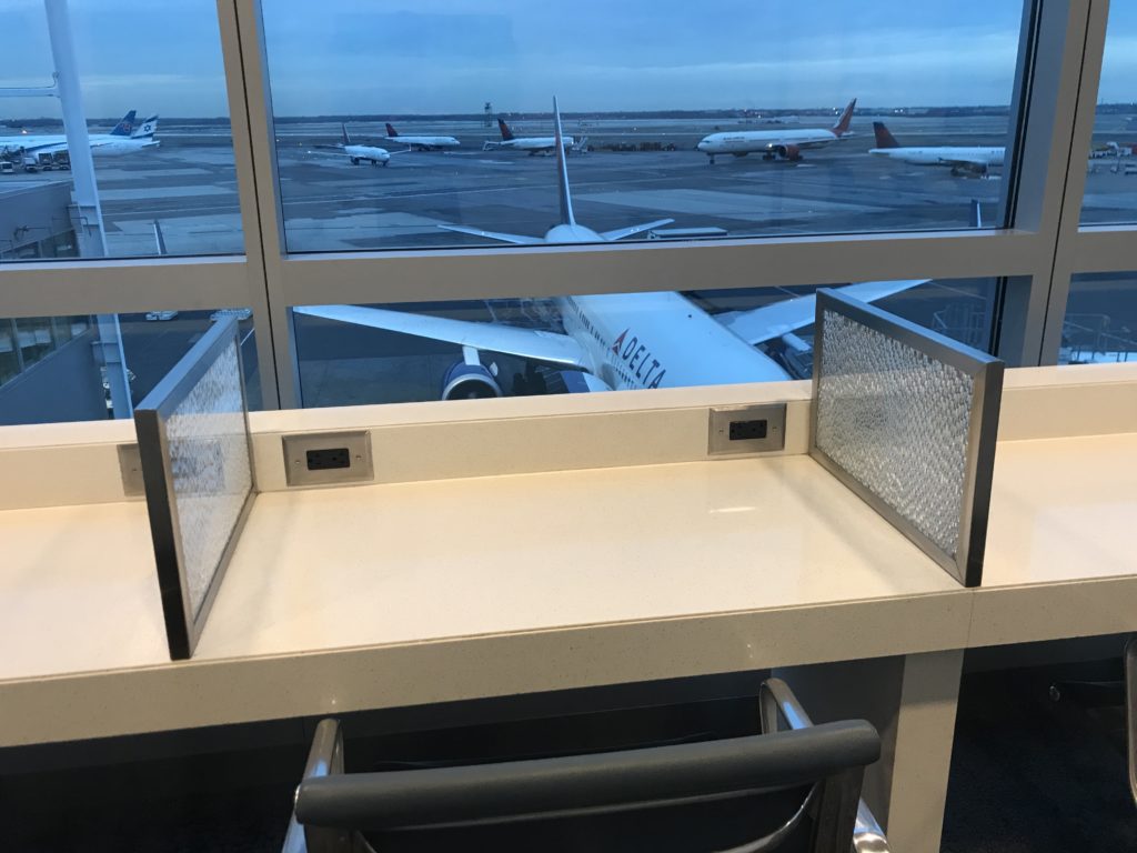 a desk with a screen on it and planes in the background