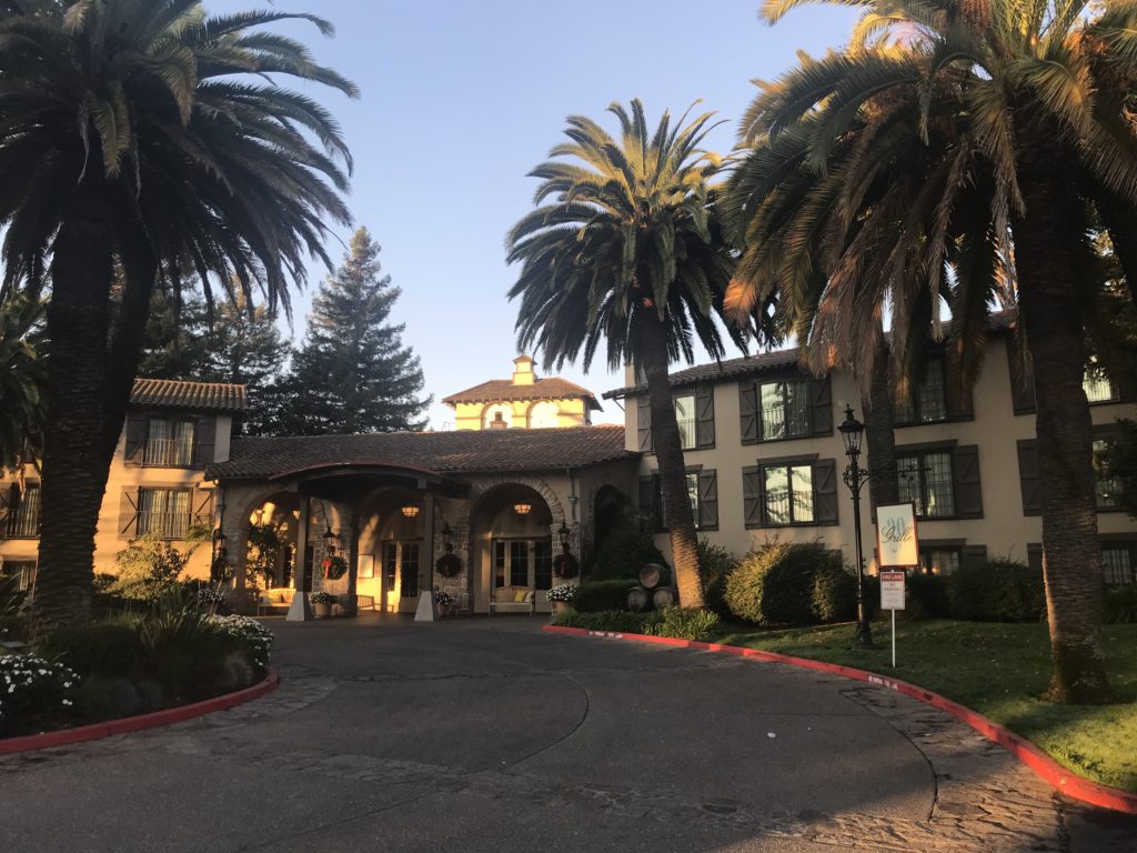 a building with palm trees and a driveway