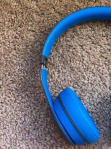 a blue headphones on carpet