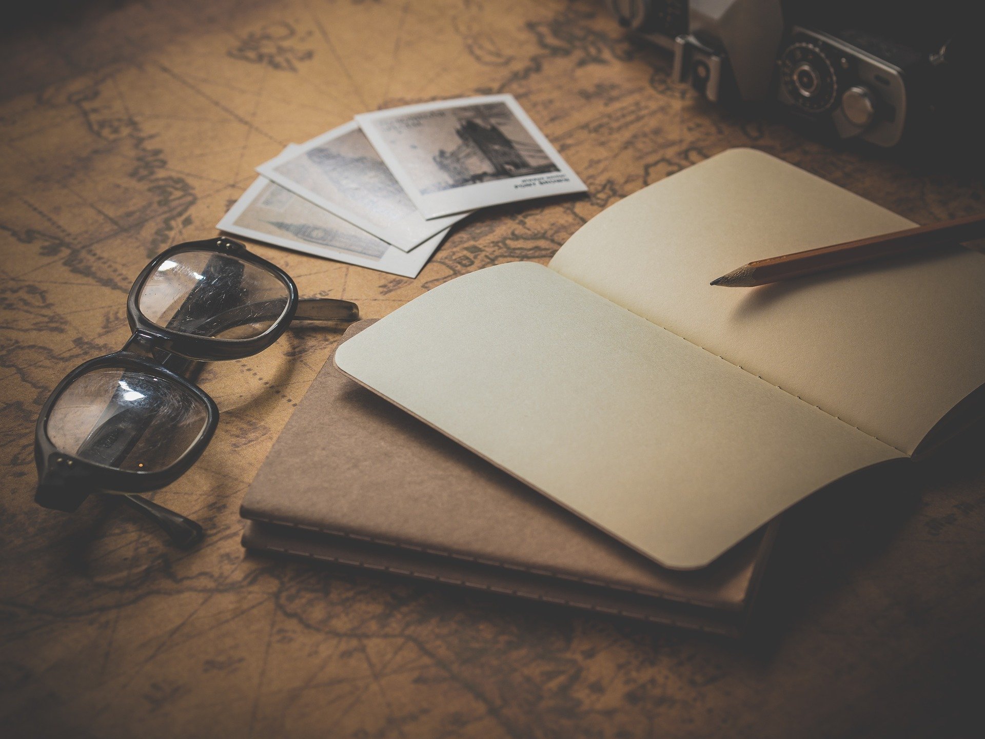 a notebook and glasses on a map