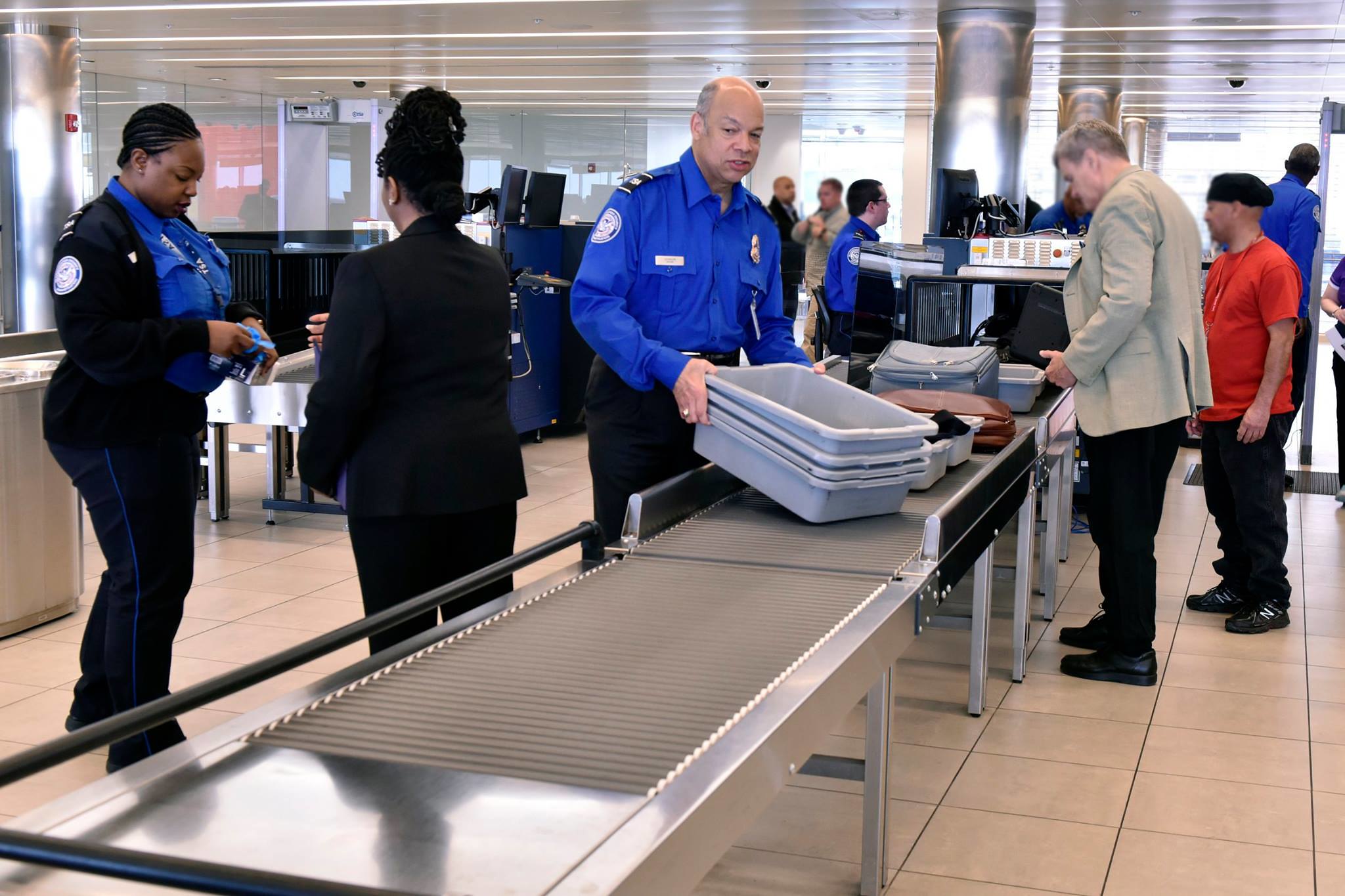 a man holding plastic containers on a conveyor belt