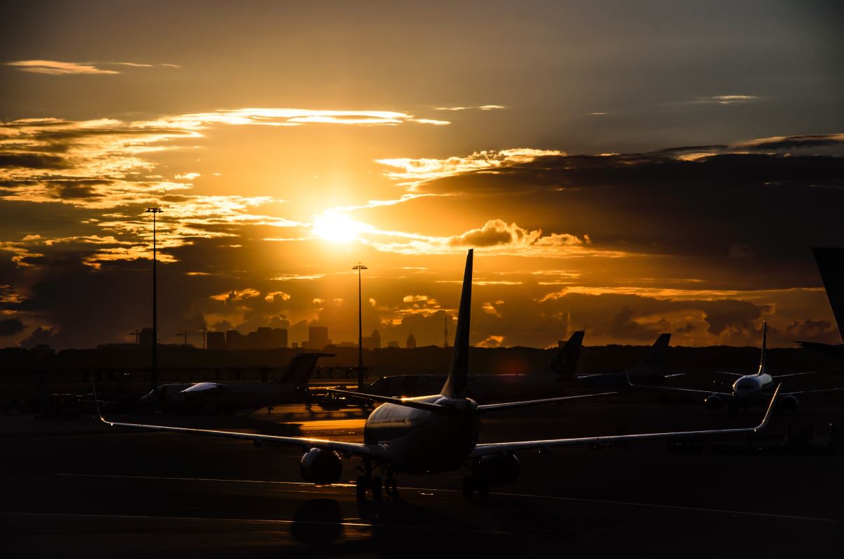 a group of airplanes on a runway at sunset