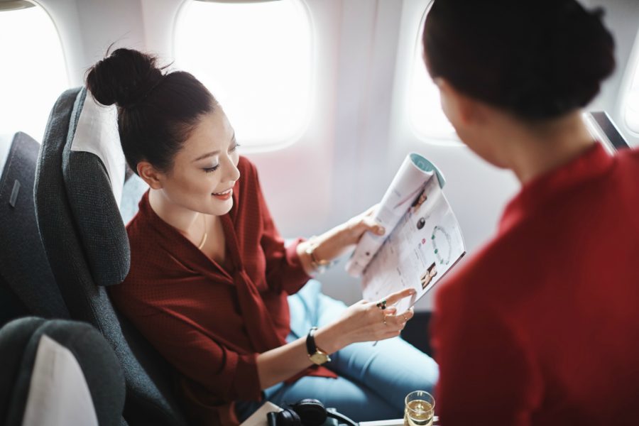 a woman looking at a magazine on an airplane