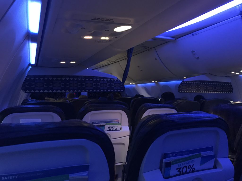 an airplane with seats and a sign on the ceiling
