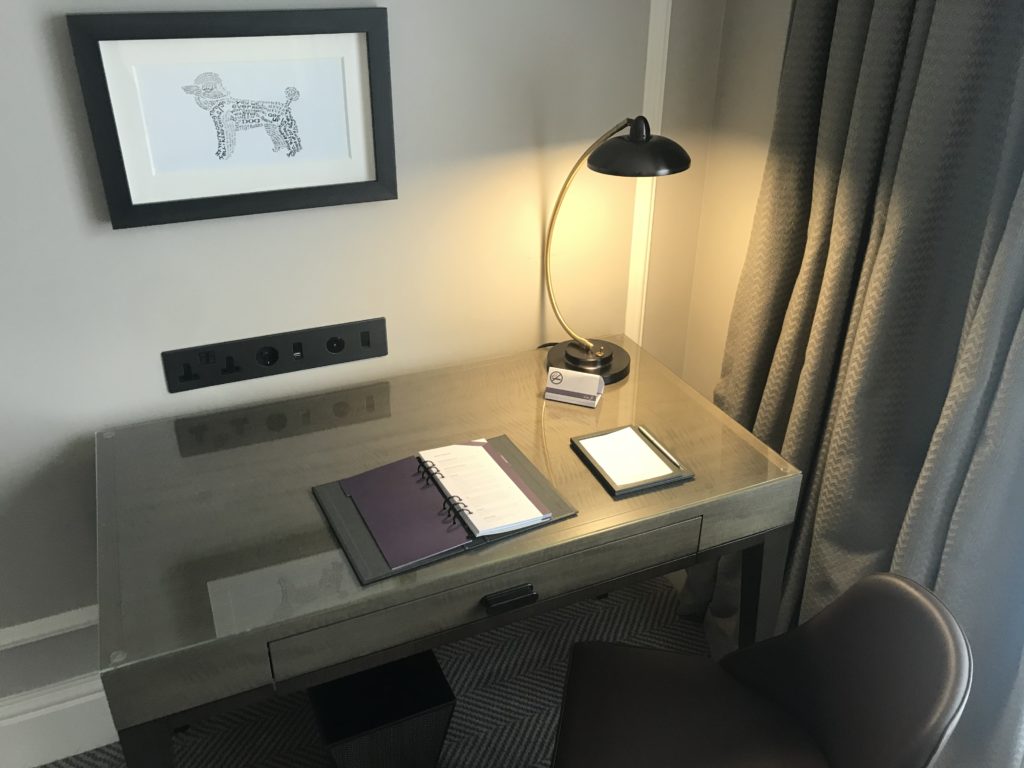 a desk with a lamp and a notebook on it