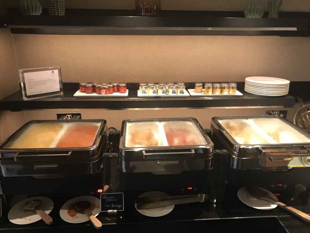 food in a buffet with plates and sauces