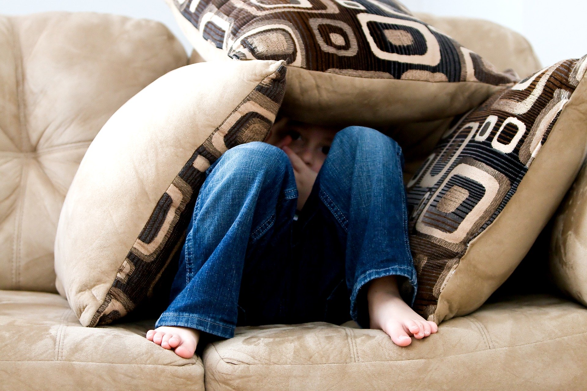 a child hiding under pillows