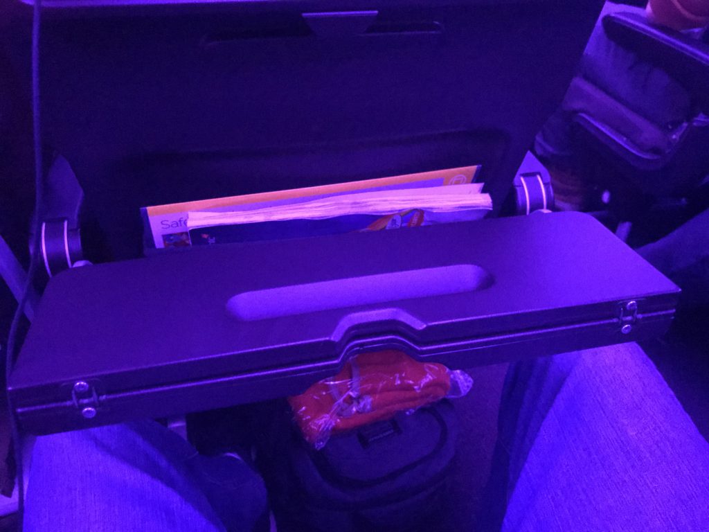 a black plastic arm rest with a magazine in it