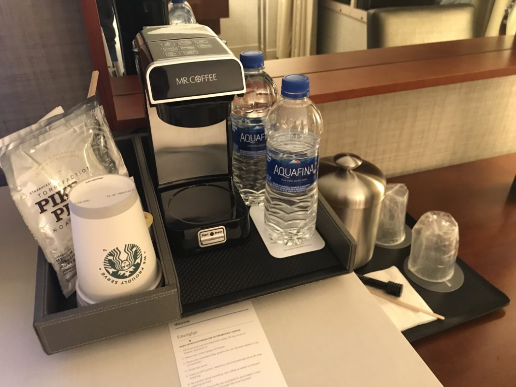 a coffee machine and water bottles on a tray
