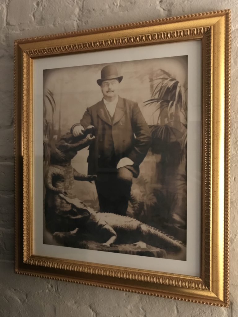 a framed picture of a man and alligators