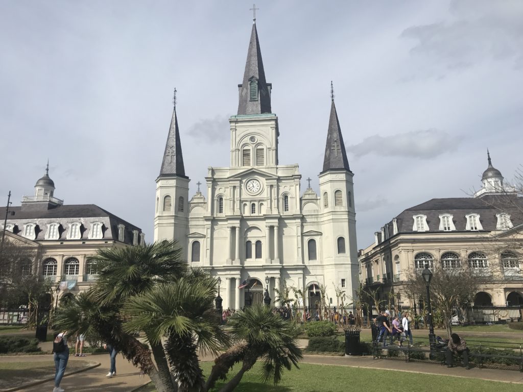 a large white building with a clock and towers