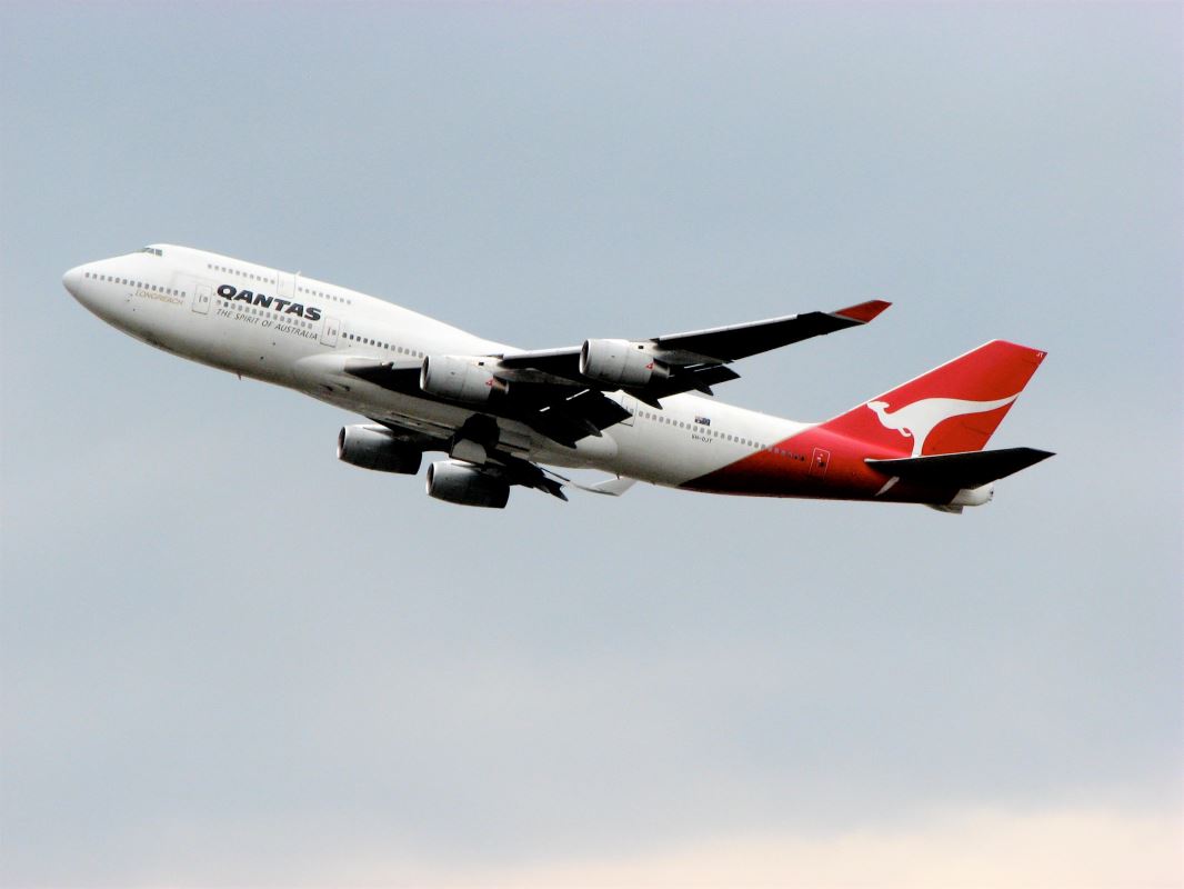 a white and red airplane flying in the sky