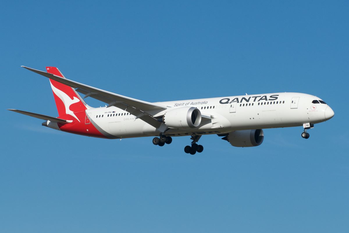 a white airplane with red and white markings flying in the sky