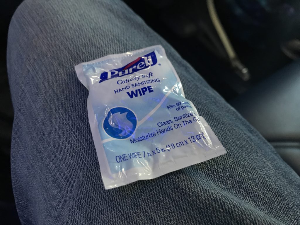 a small white package of hand sanitizer on a blue jeans