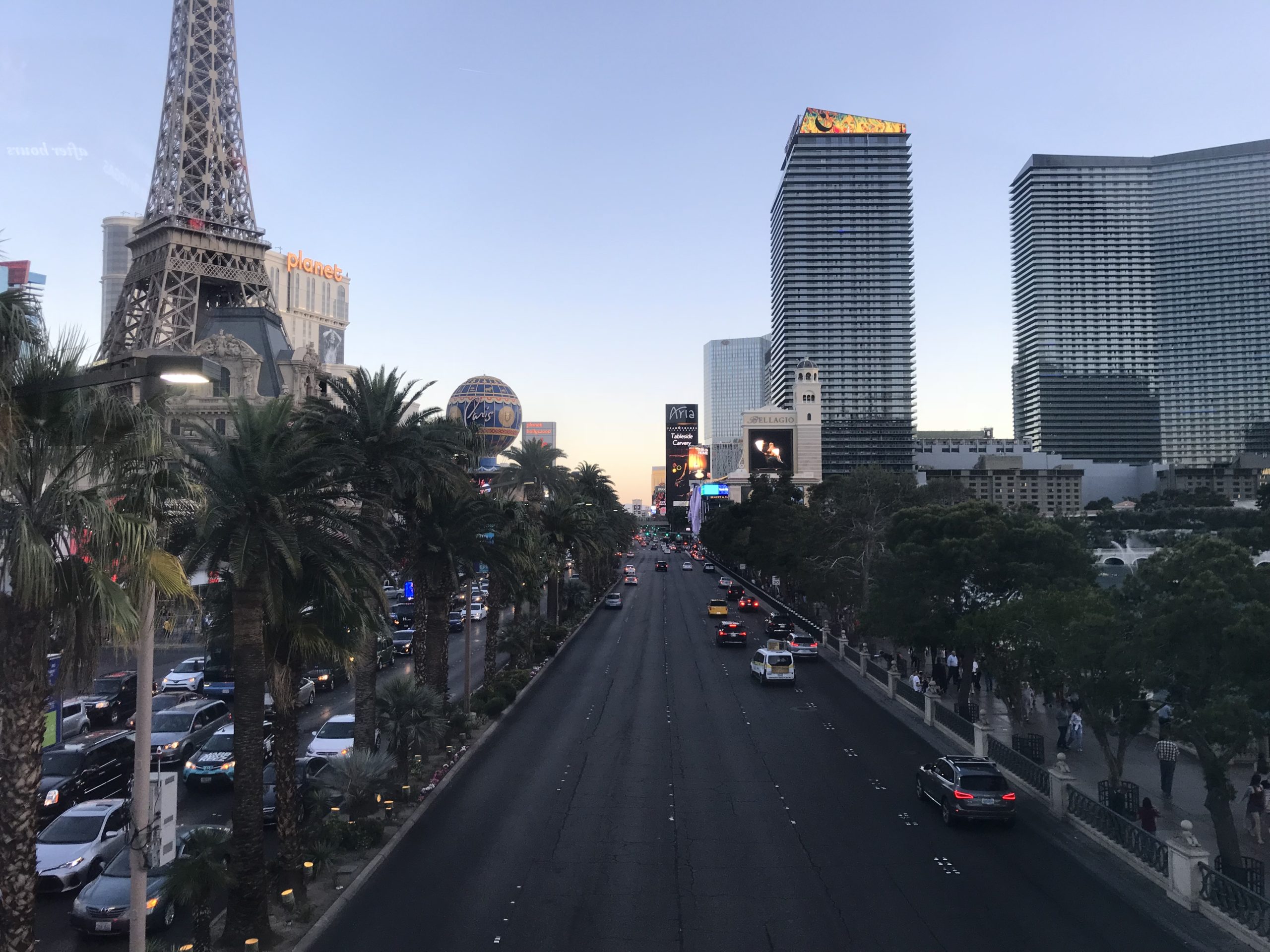 a road with cars and trees in front of a tall tower