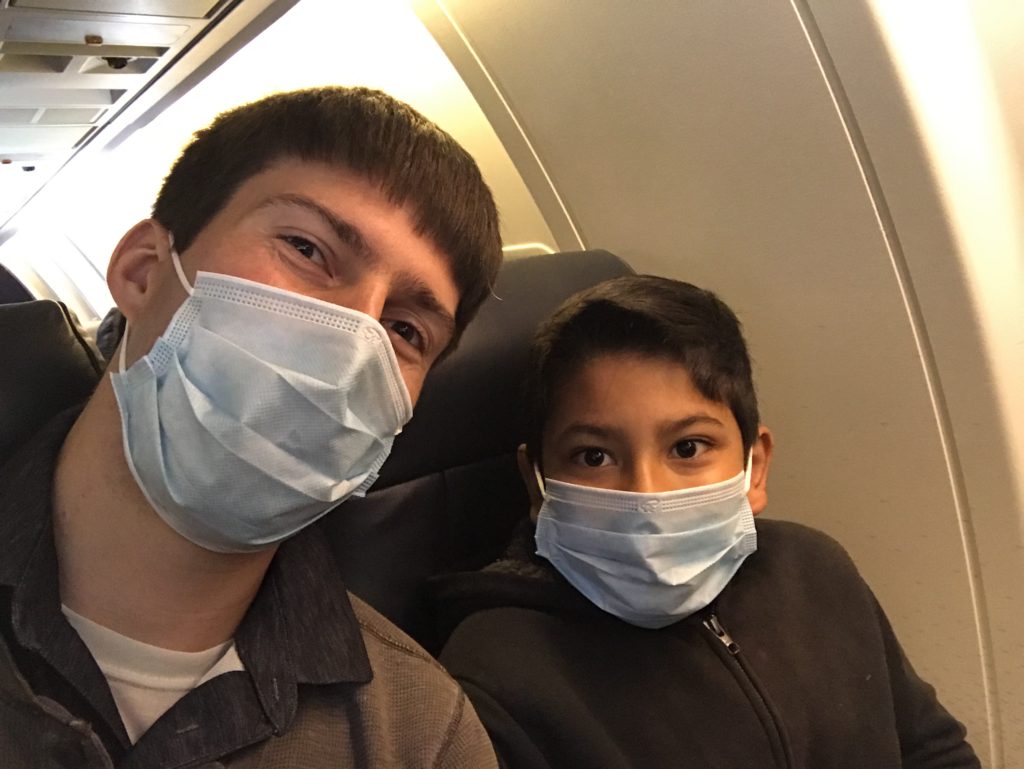 two people wearing masks on an airplane