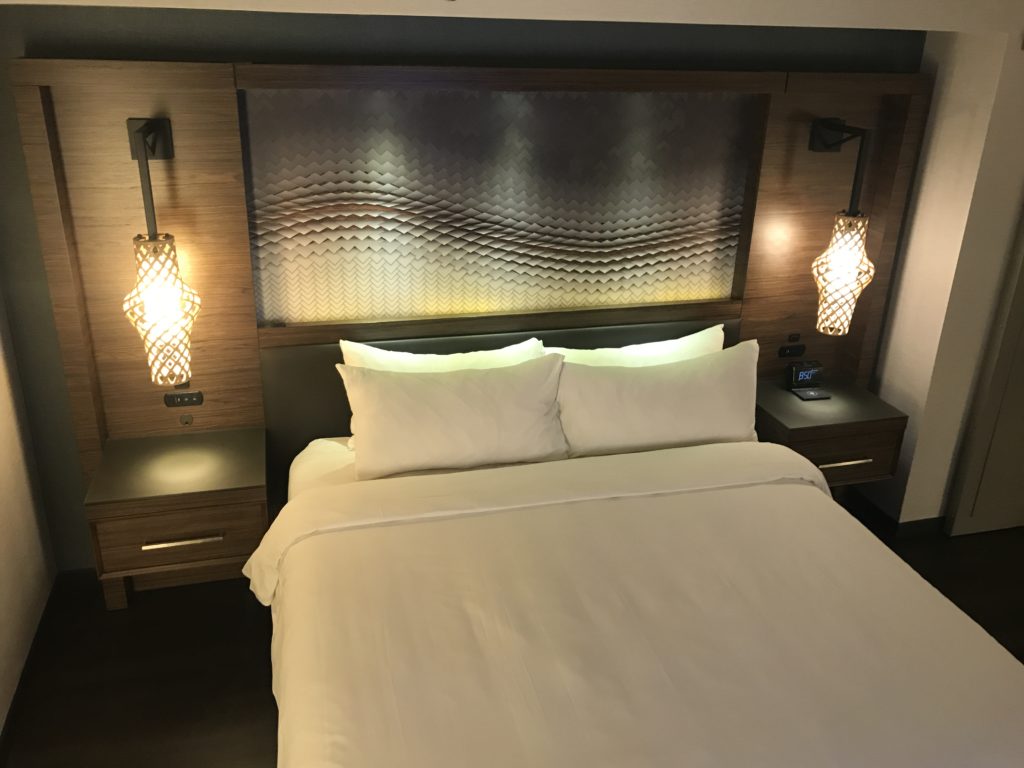 a bed with lamps on the headboard