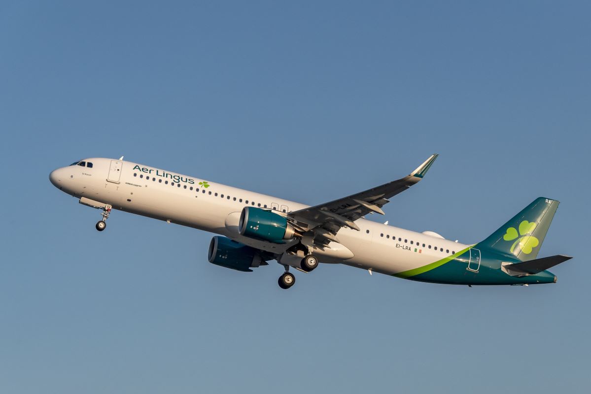 a white and green airplane flying in the sky