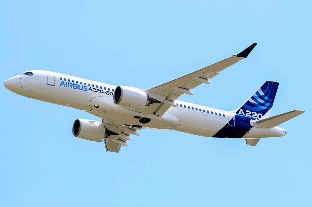 a white and blue airplane flying in the sky